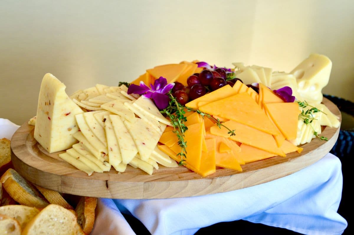 Sliced cheeses on a wooden board